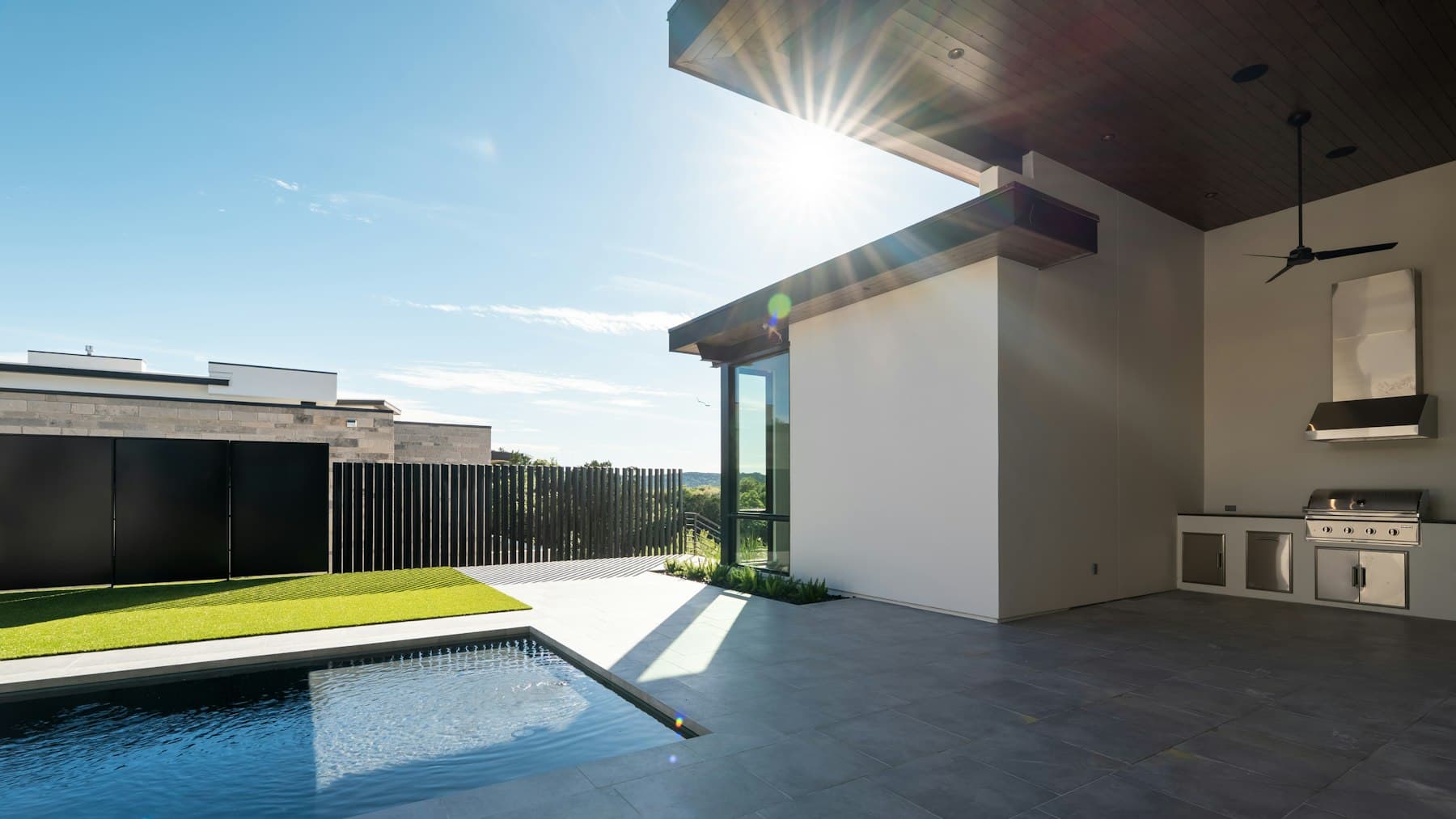 Modern backyard with a swimming pool and outdoor kitchen, the kind of project San Diego pool builders design