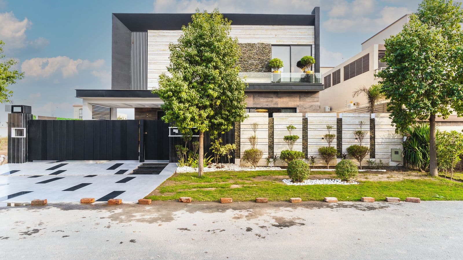 Contemporary luxury home with a manicured front garden and a wide geometric driveway leading to the entrance
