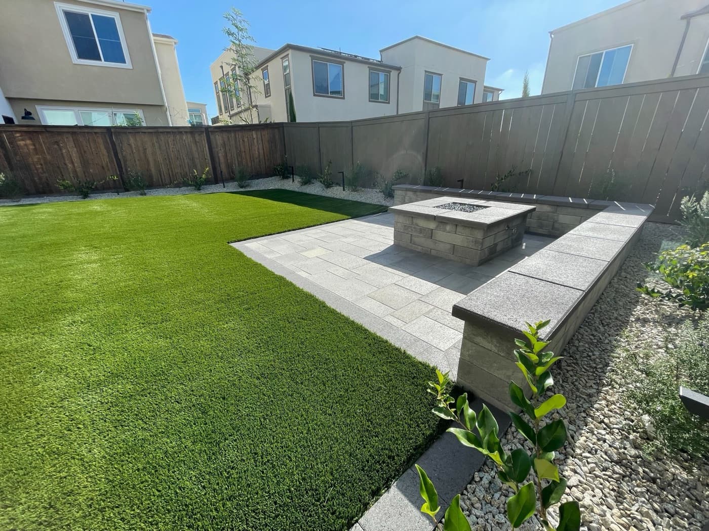 Fire pit and paver patio with lawn in Carlsbad by Modern Yardz