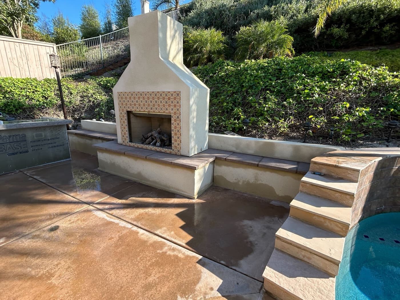 Outdoor fireplace beside the pool in Carlsbad by Modern Yardz