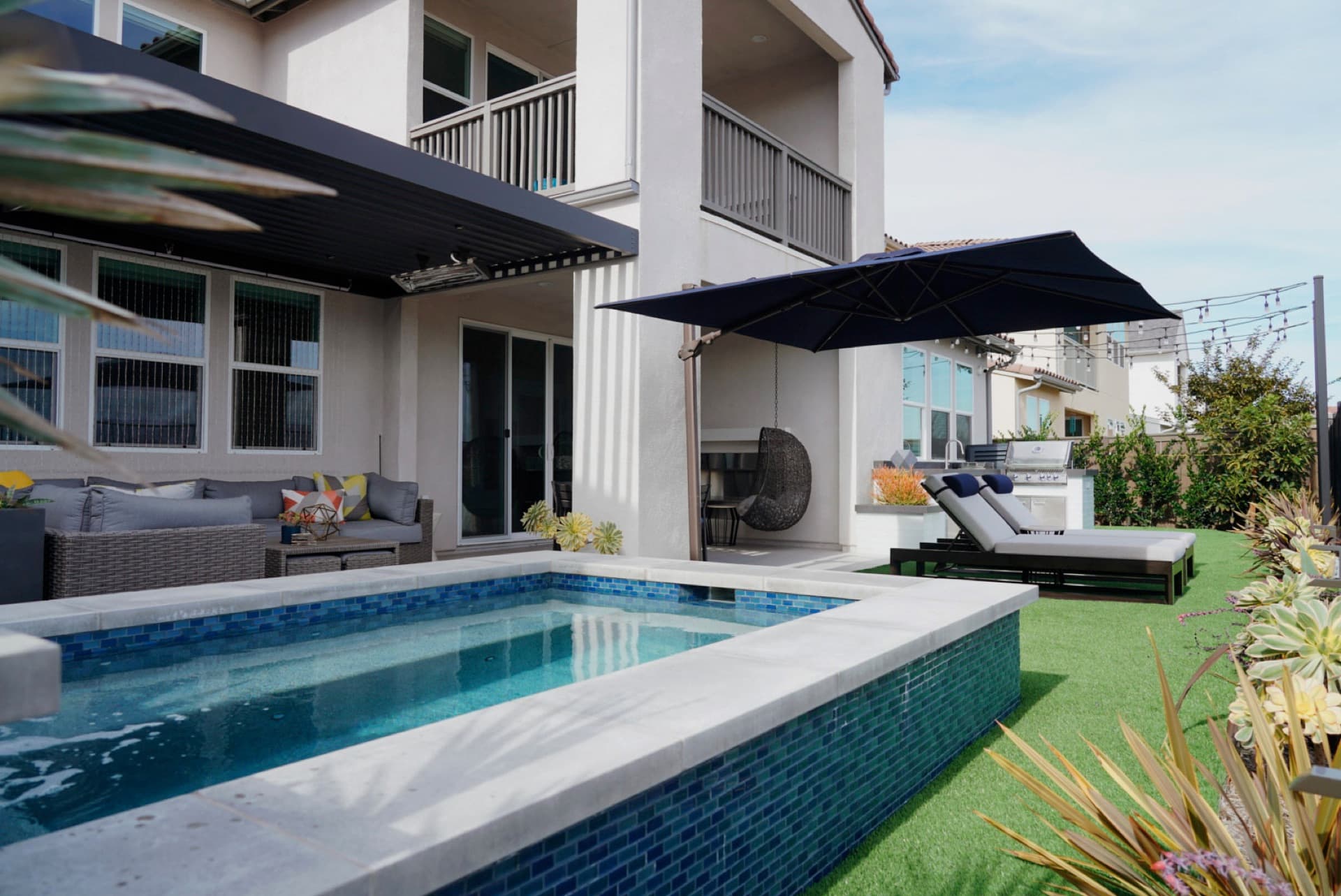 Blue-tile pool with cantilever shade, designed and built by Modern Yardz in Del Mar, San Diego County