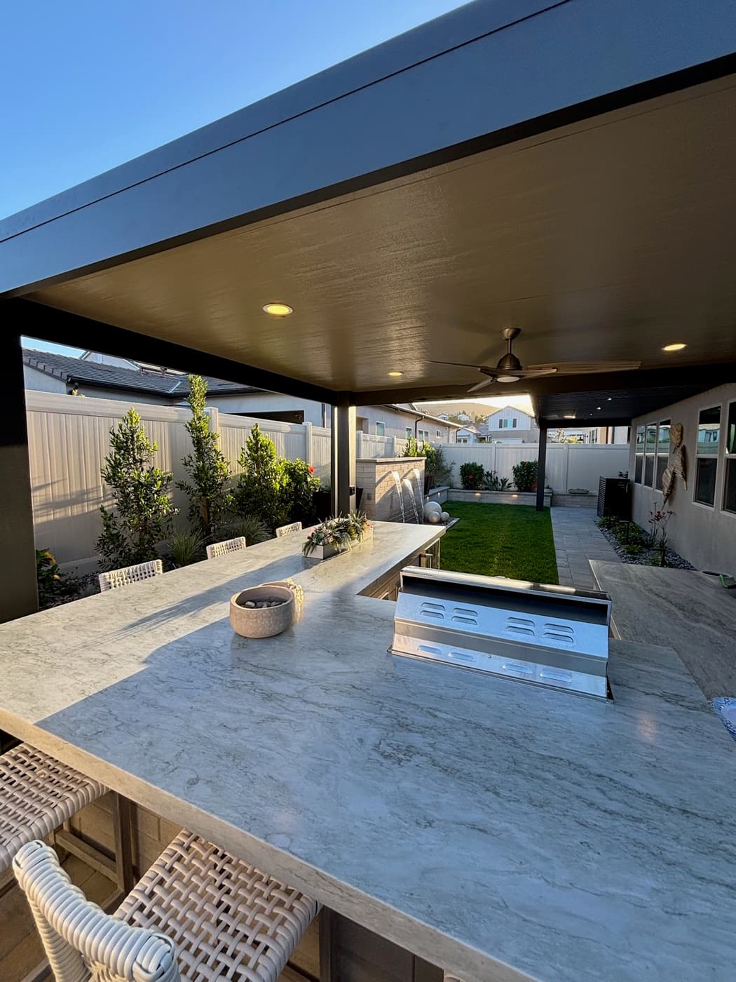 Covered patio with a marble outdoor kitchen in Encinitas by Modern Yardz
