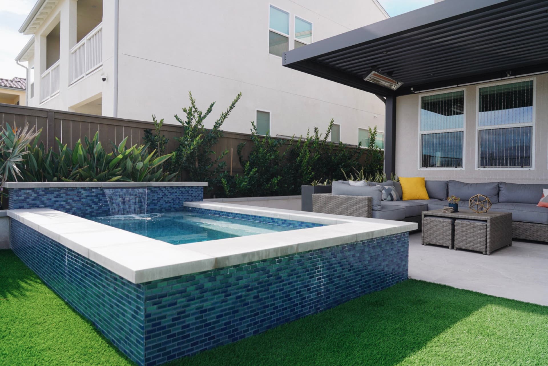 Blue-tile spa and pool with a louvered pergola in Oceanside by Modern Yardz