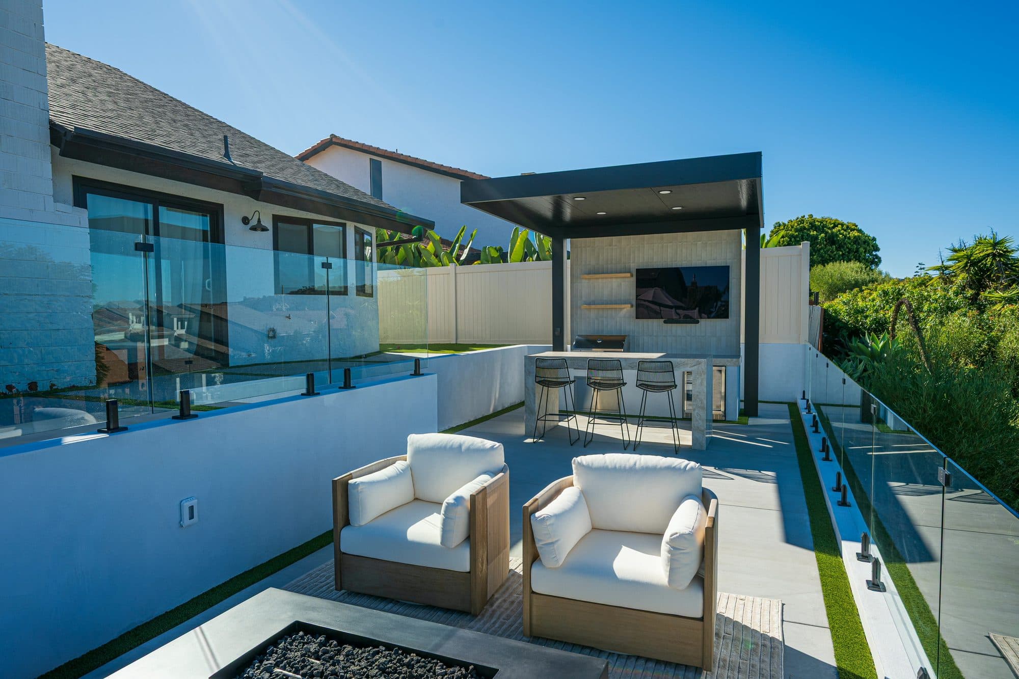 Fire table and frameless glass railing on a view terrace by Modern Yardz in Carlsbad