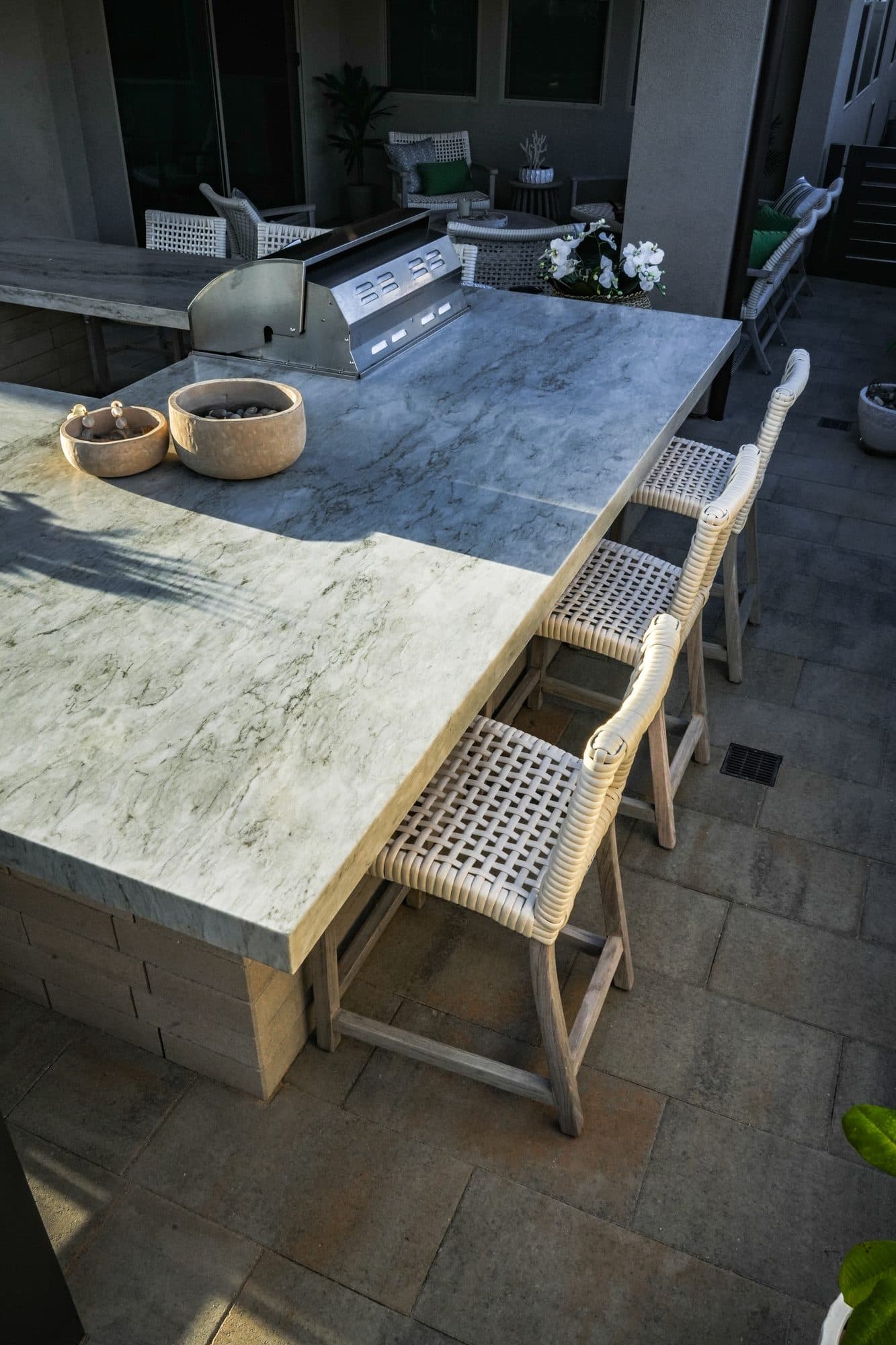 Mitered porcelain dining table with seating under the insulated patio cover