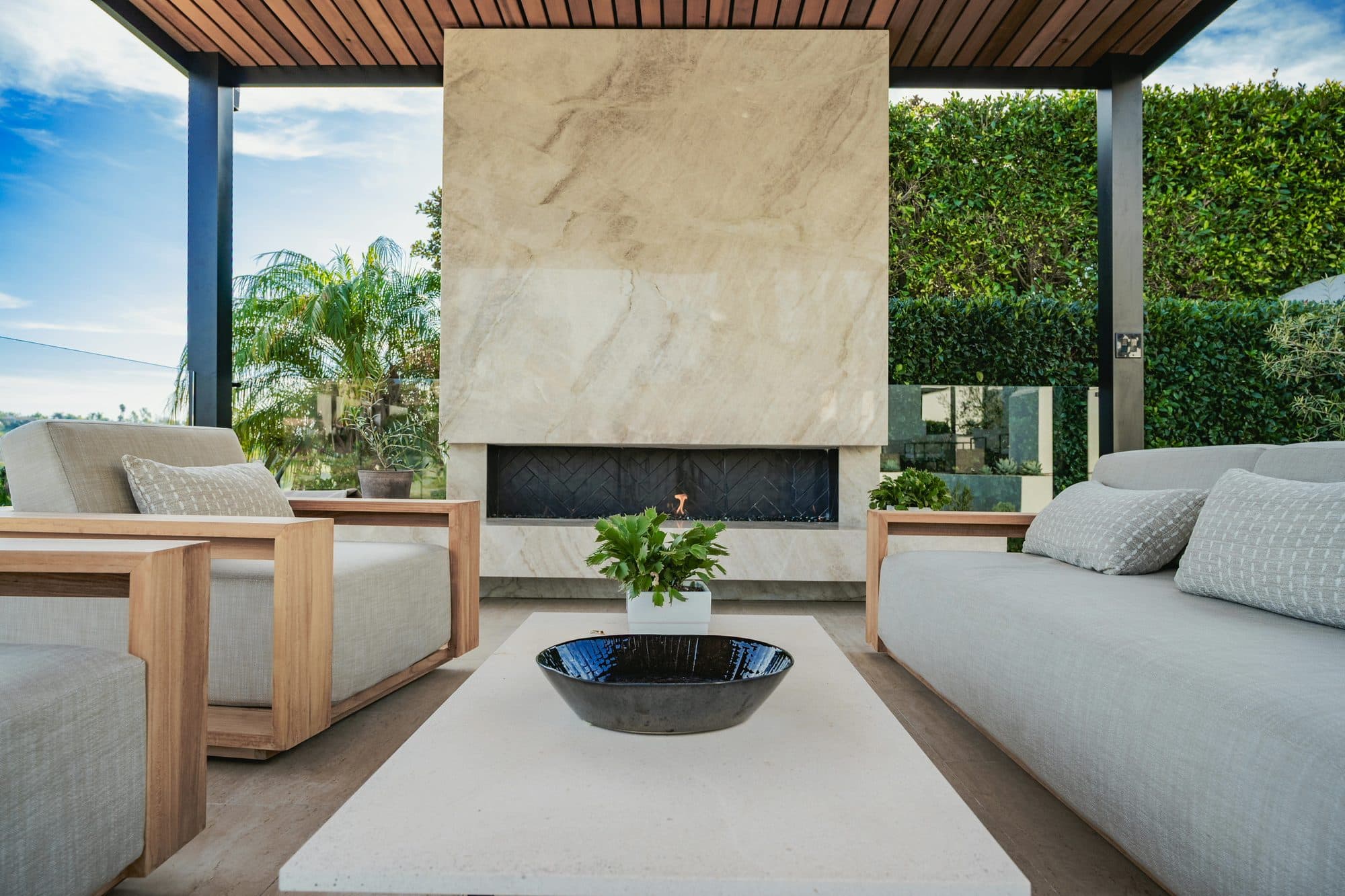 Floor-to-ceiling Taj Mahal quartzite fireplace with a floating hearth beneath a cedar ceiling, Rancho Santa Fe