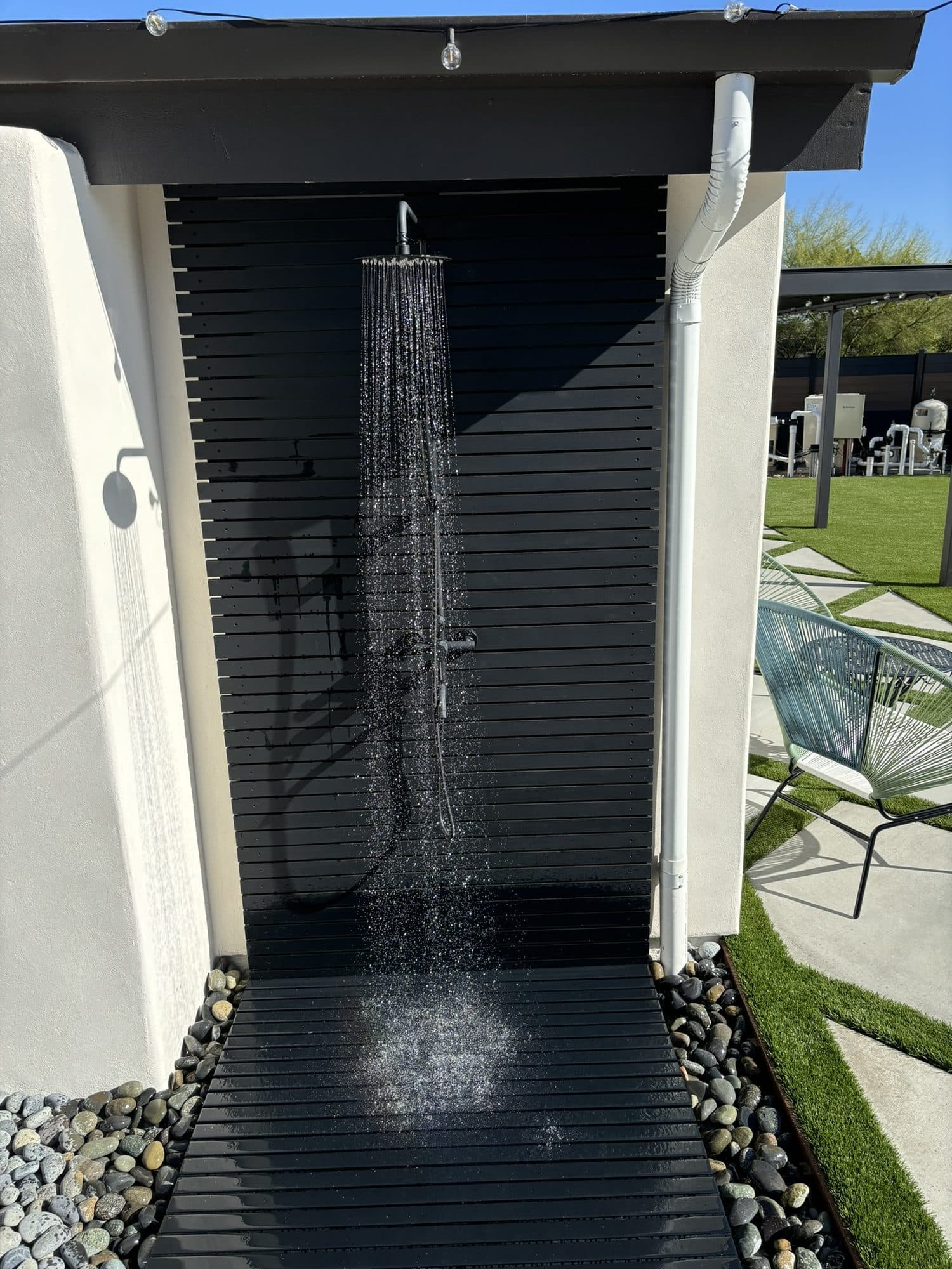 Ipe-wood outdoor shower running beside the pool deck
