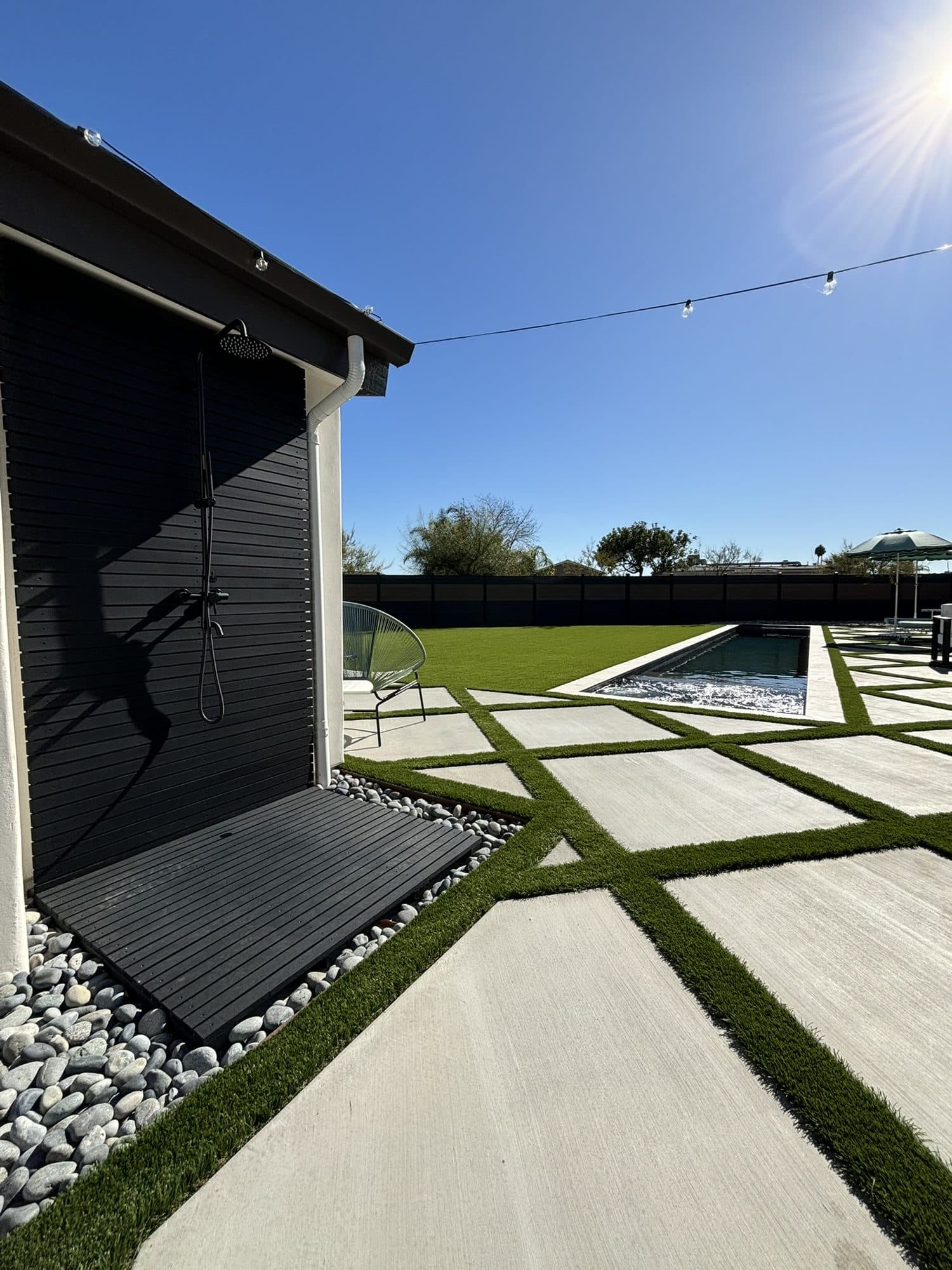 Outdoor shower beside the diamond concrete pavers in the side yard