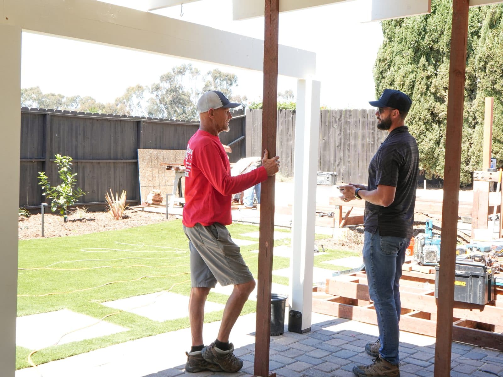 Modern Yardz crew setting a support post for a solid-roof patio cover over a paver patio in San Diego
