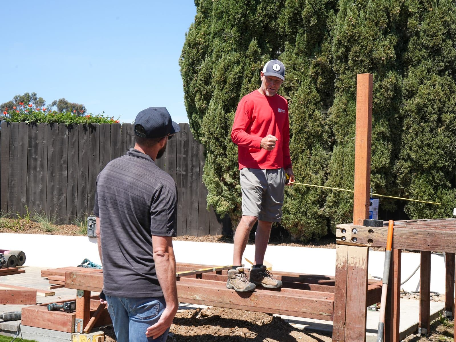 Modern Yardz crew laying out pergola framing on a San Diego backyard build