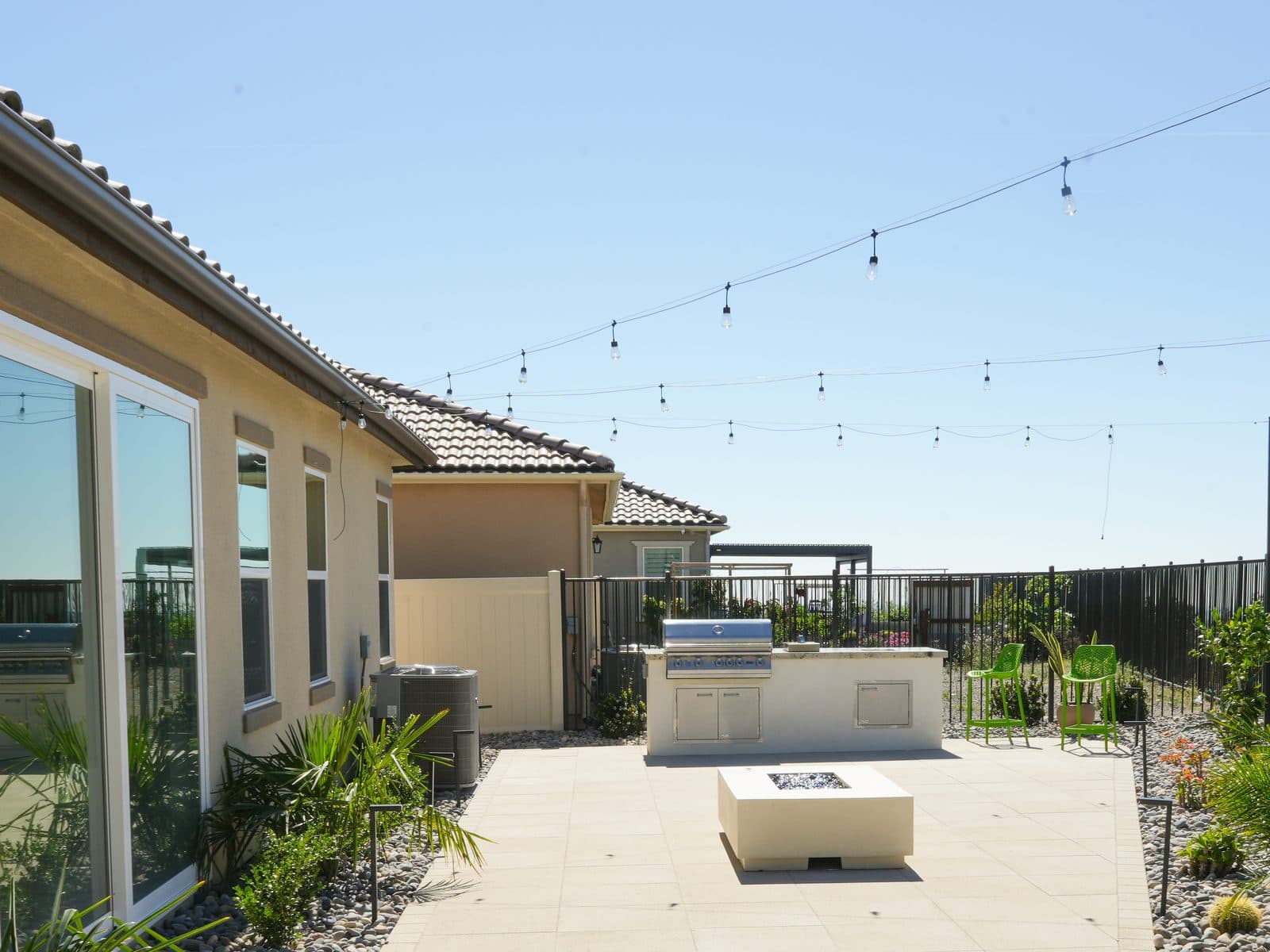 Linear gas fire table set into a paver patio beside a built-in grill, by Modern Yardz San Diego